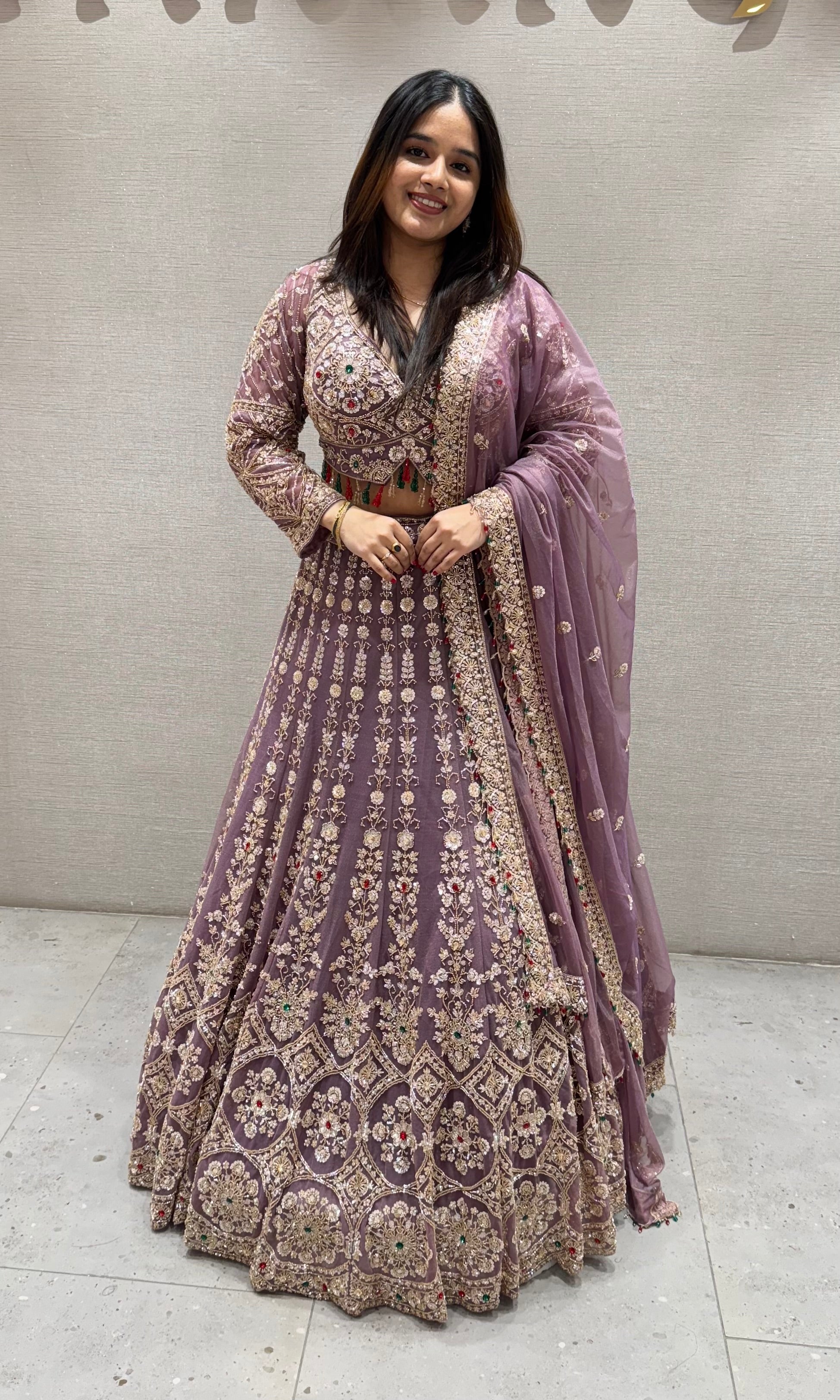 Purple lehenga with green and red contrast jewellery