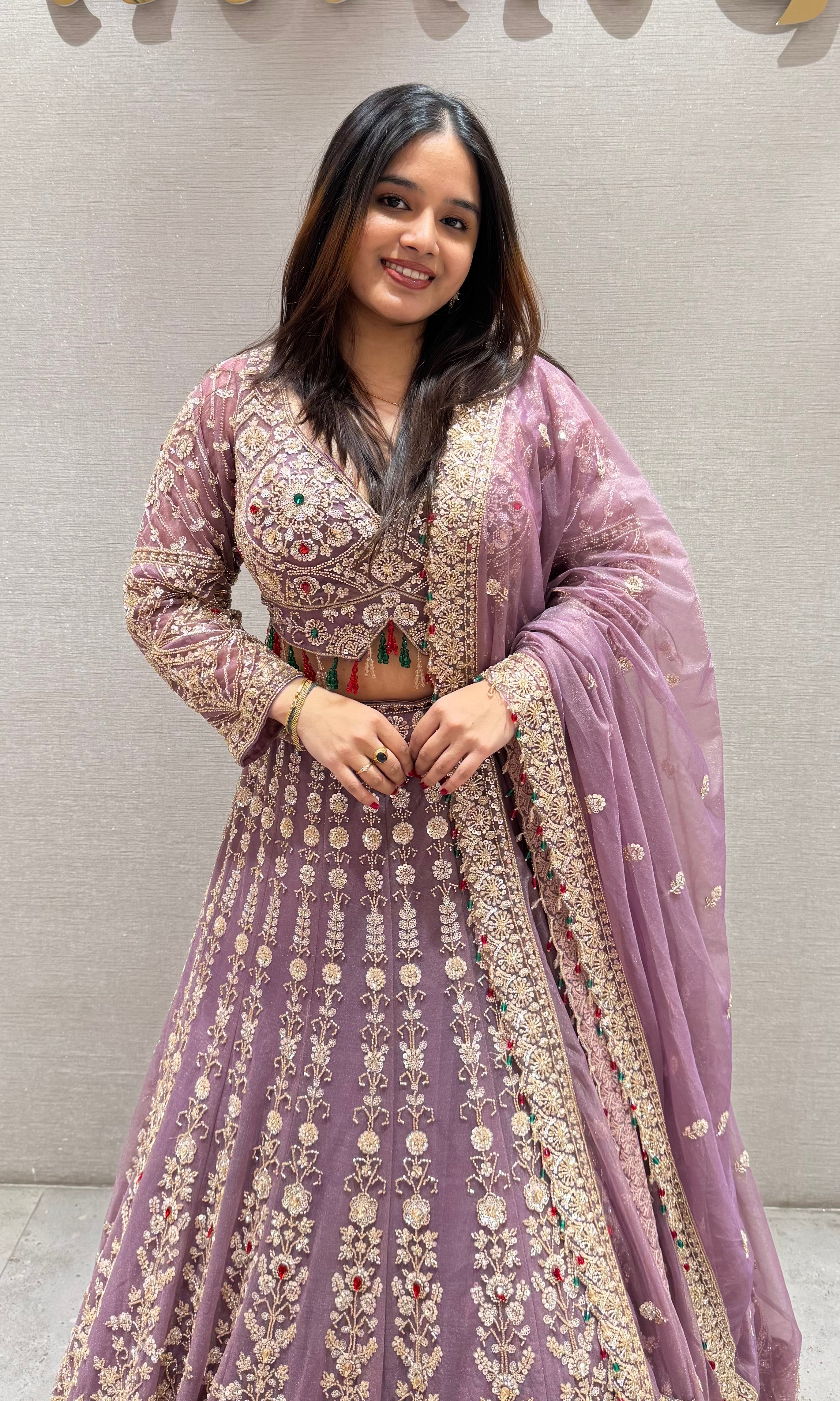 Purple lehenga with green and red contrast jewellery