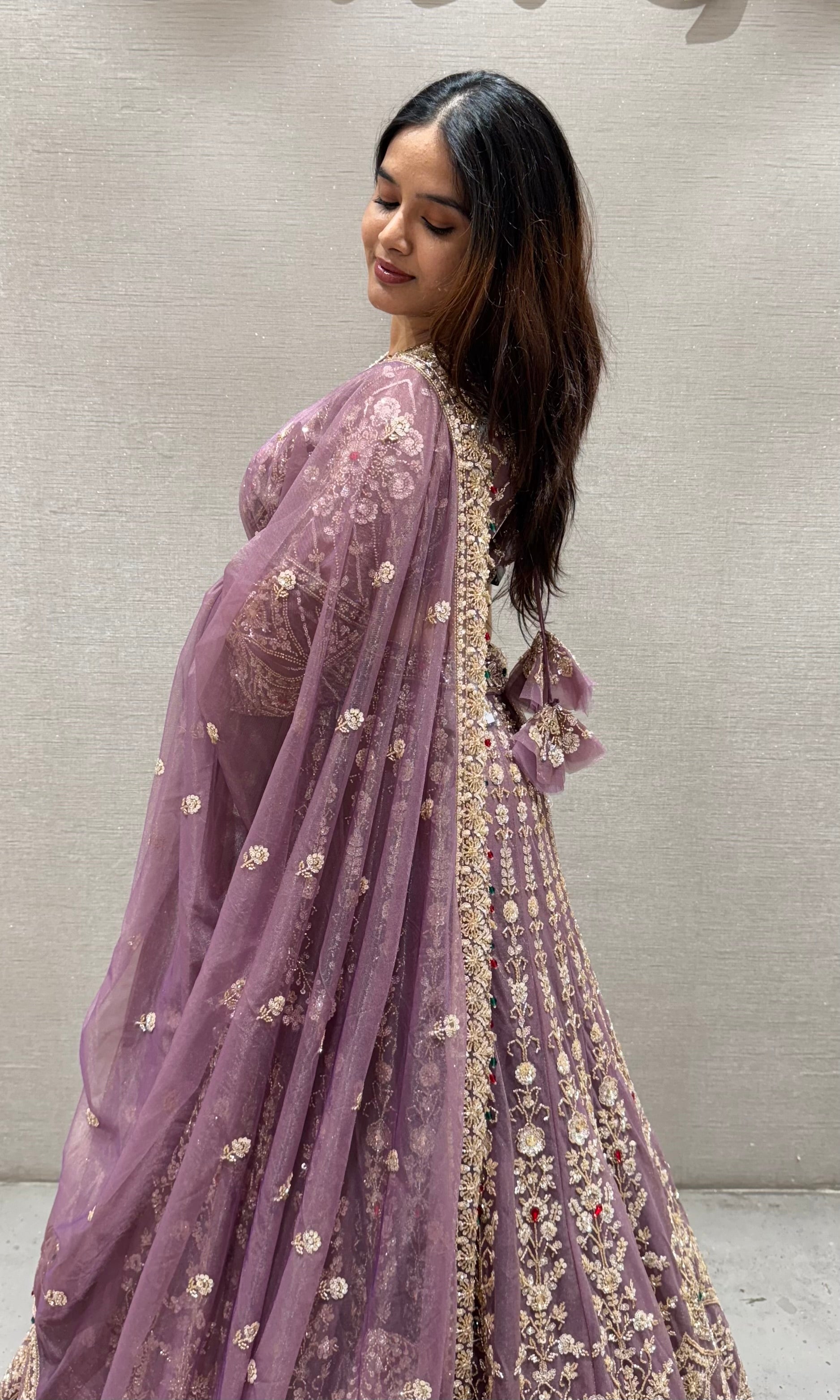 Purple lehenga with green and red contrast jewellery