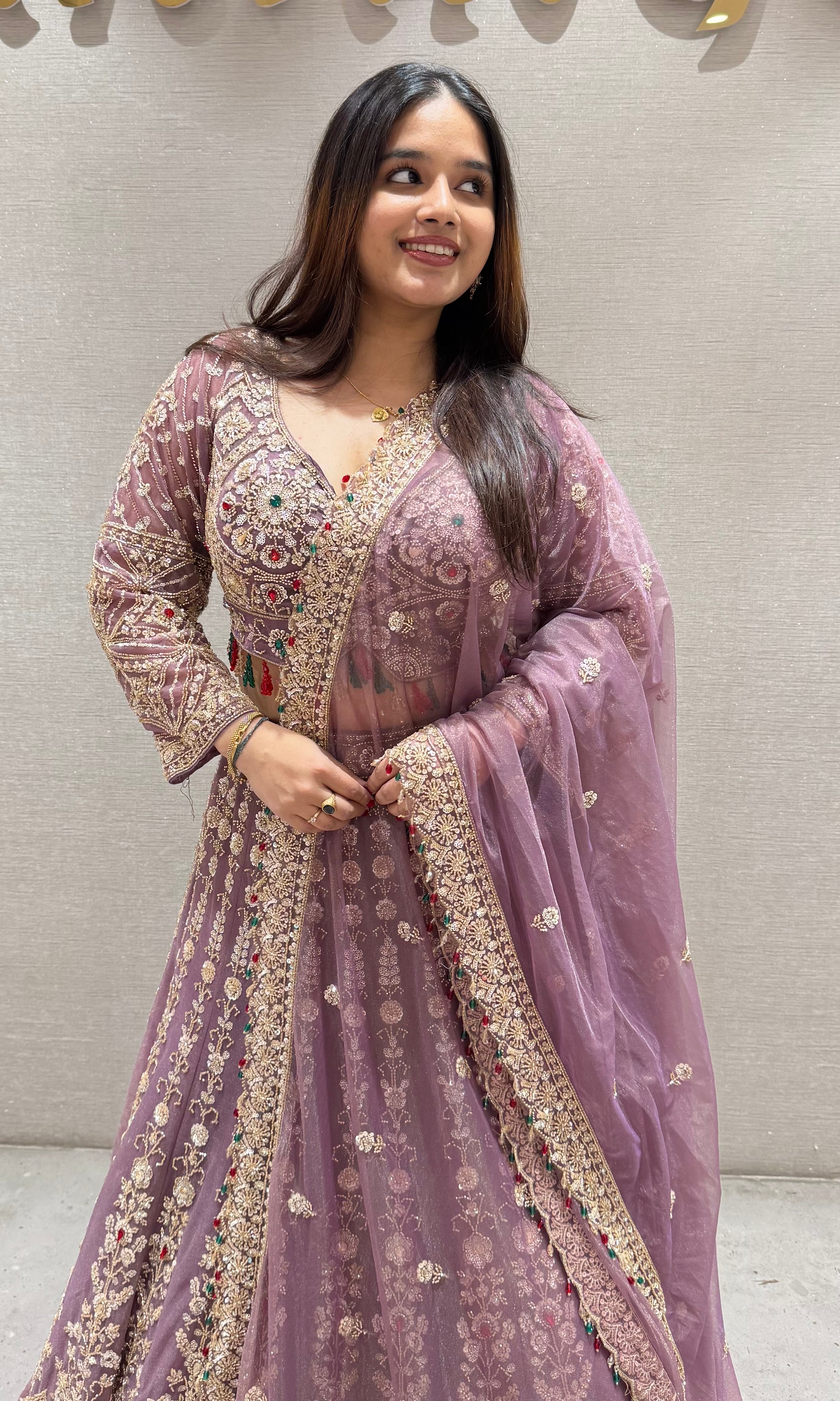 Purple lehenga with green and red contrast jewellery