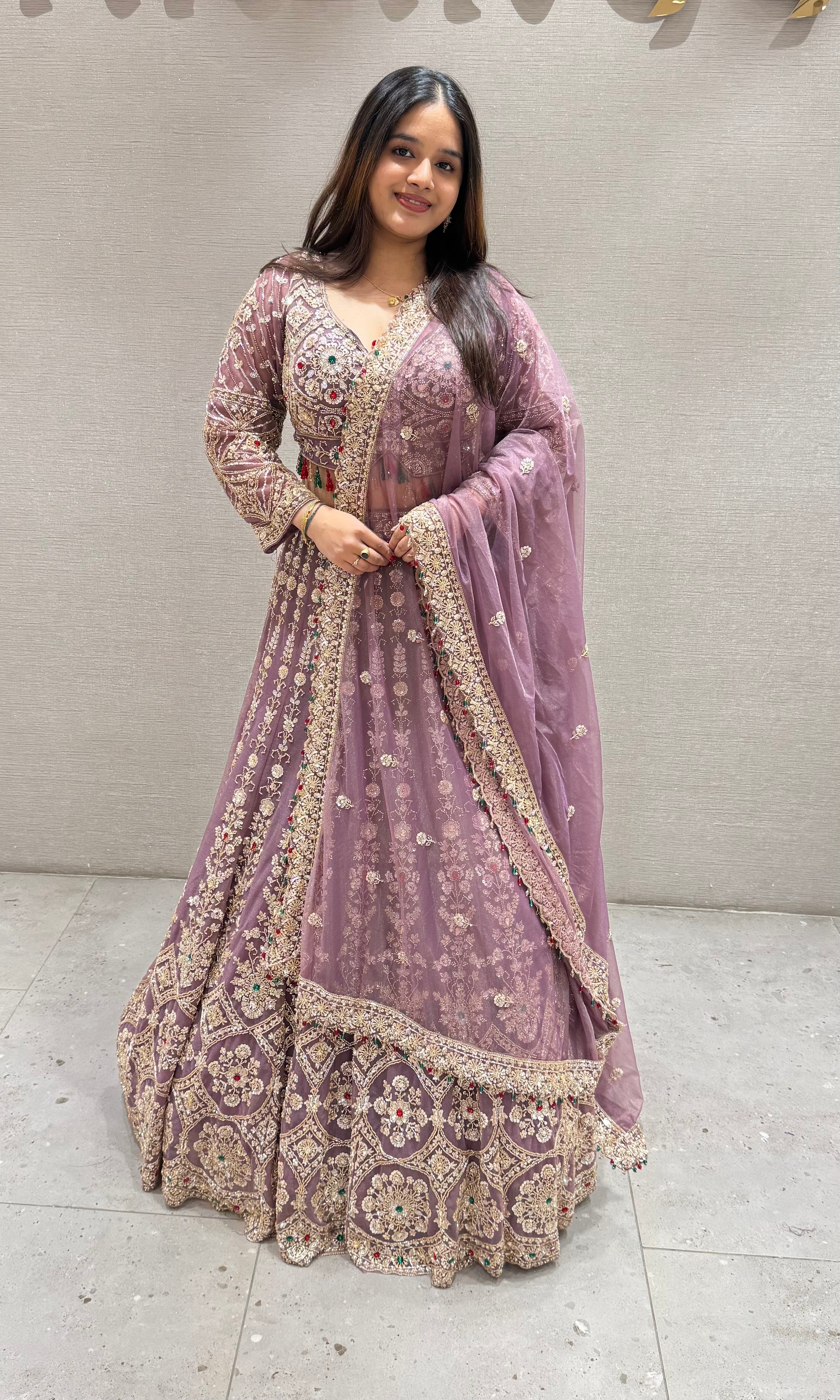Purple lehenga with green and red contrast jewellery